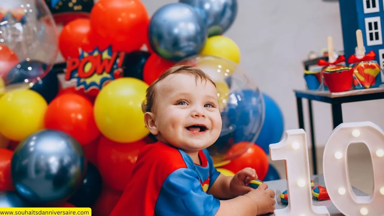 Un garçon sourit joyeusement lors de son anniversaire tout en regardant l'appareil photo, entouré de magnifiques ballons et de décorations d'anniversaire. Joyeux anniversaire, garçon!