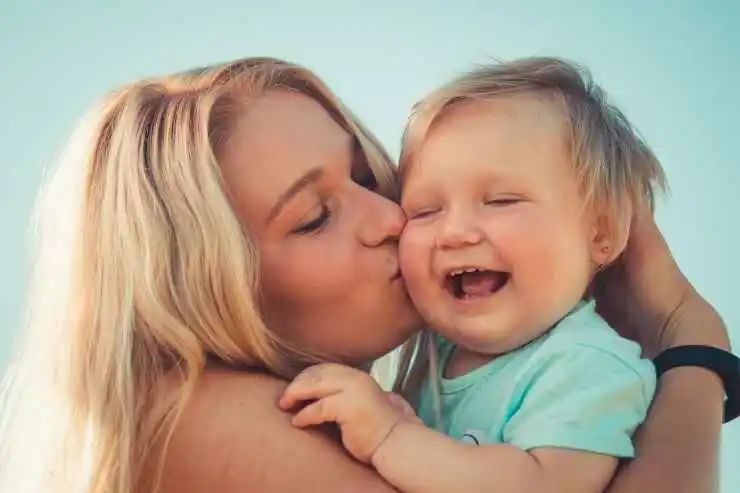 Une maman mignonne embrassant son fils mignon