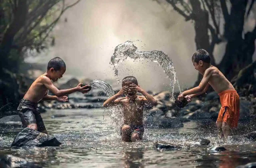3 enfants jouent dans l'eau