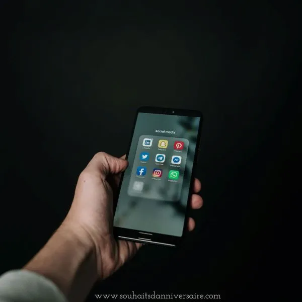Main tenant un téléphone avec une application de médias sociaux à l'écran. Reflète l'ère moderne de la connectivité et de l'interaction numérique.
