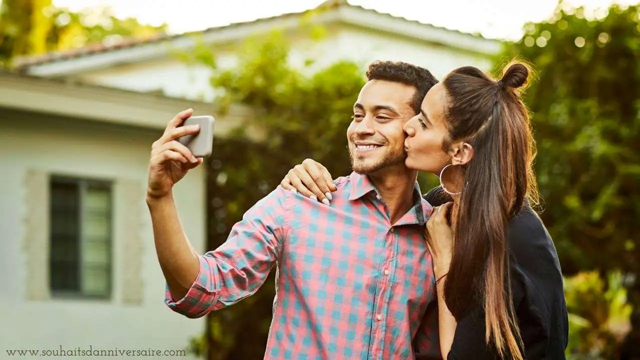 Petit ami prenant un selfie pendant que sa petite amie l'embrasse sur un fond pittoresque et flou.